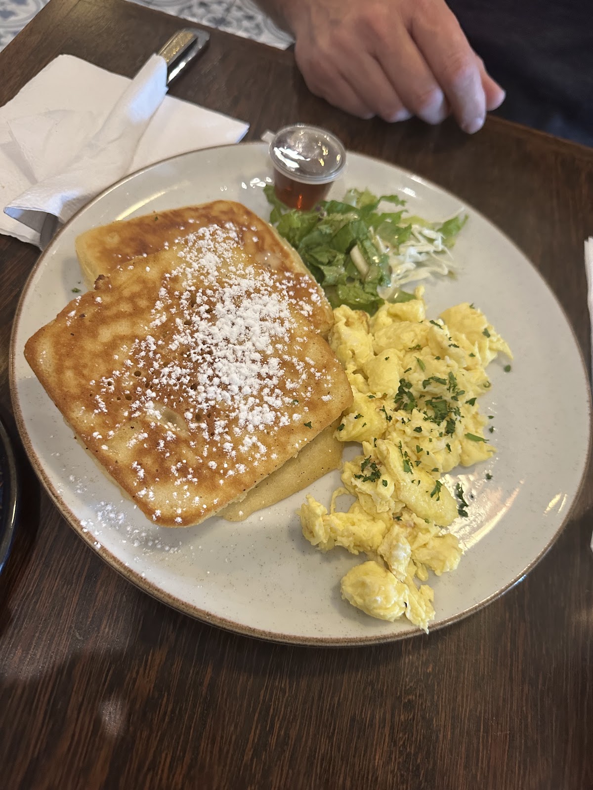 French toast with powdered sugar and scrambled eggs